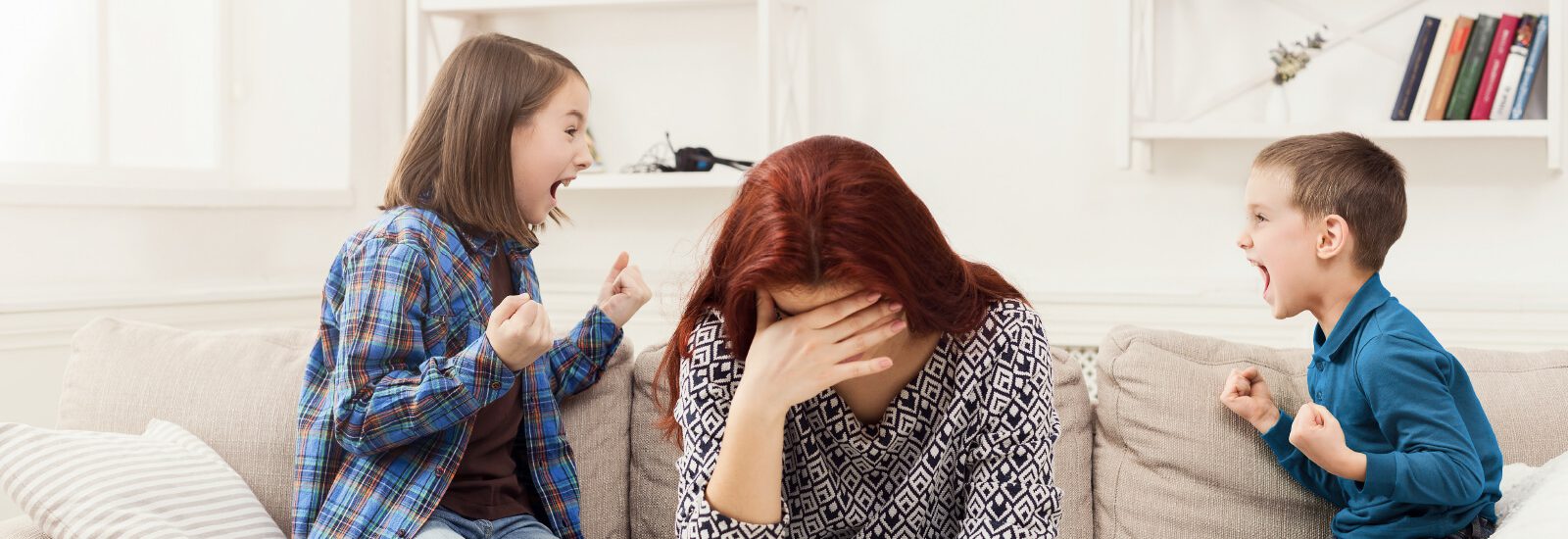 אמא יושבת מחזיקה את ראשה מאחריה שני אחים מתווכחים-הדרכה לבעיות התנהגות